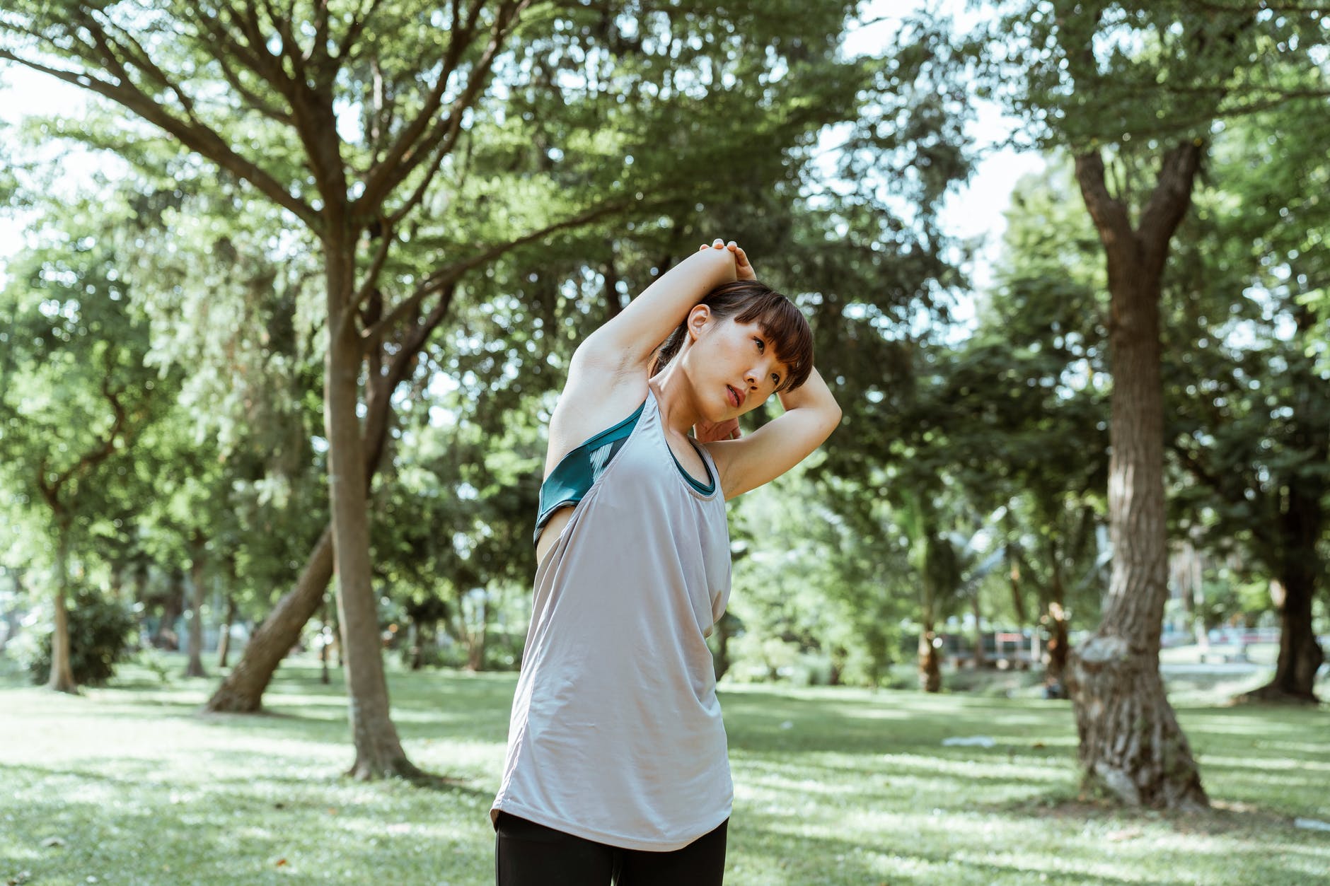 flexible ethnic woman in sportswear in park